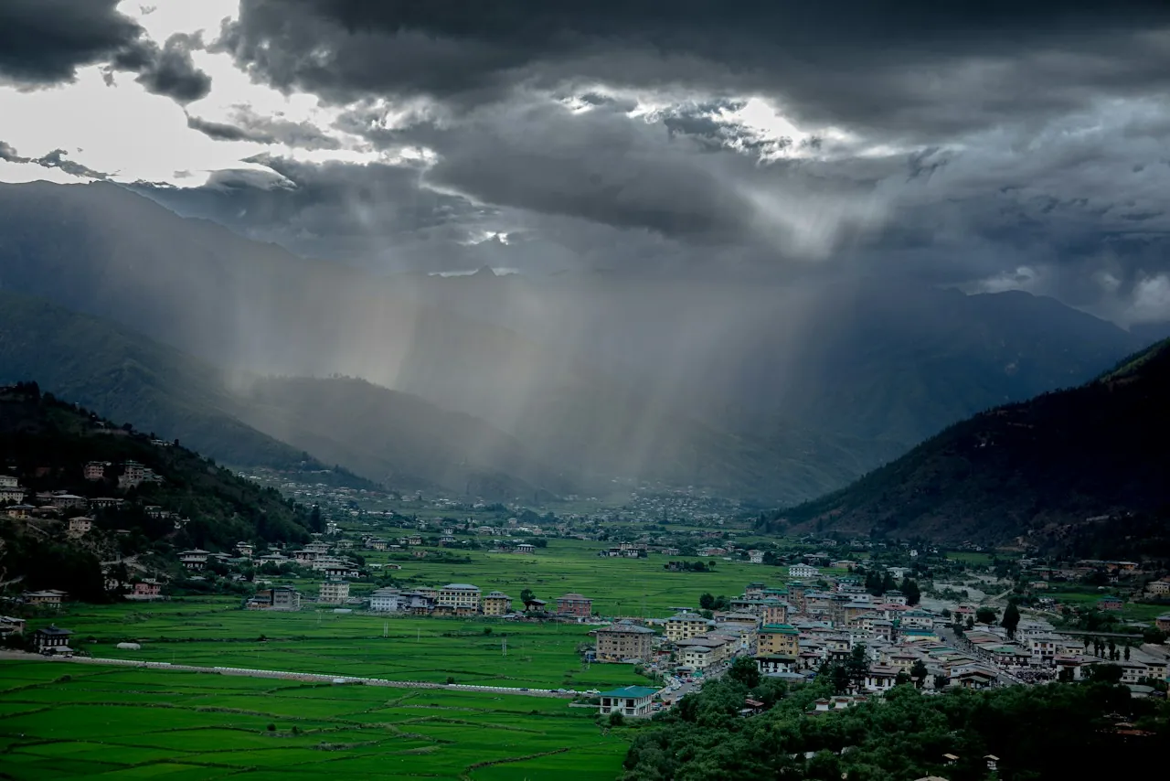 Roof Replacement in Hesperia — rain sweeping down a valley toward a town